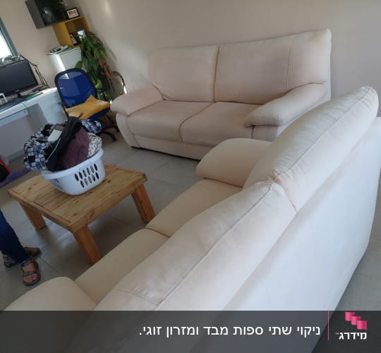 ספות בהירות בחדר עם שולחן קטן